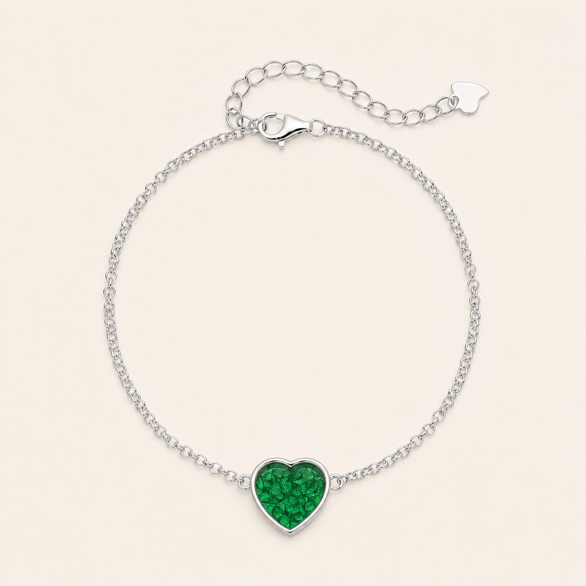 lver chain bracelet with a heart-shaped green crystal charm