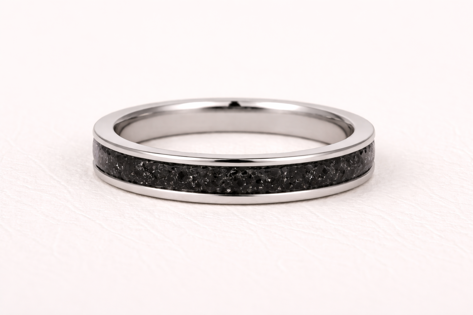 Silver ring with black inlay on a white background