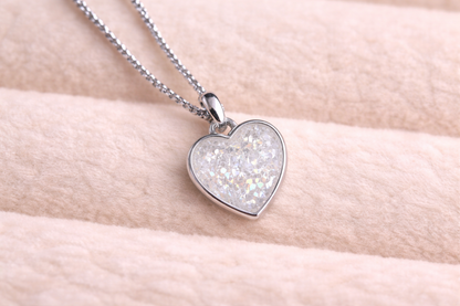 Heart-shaped pendant necklace with glittery interior on a light skin background
