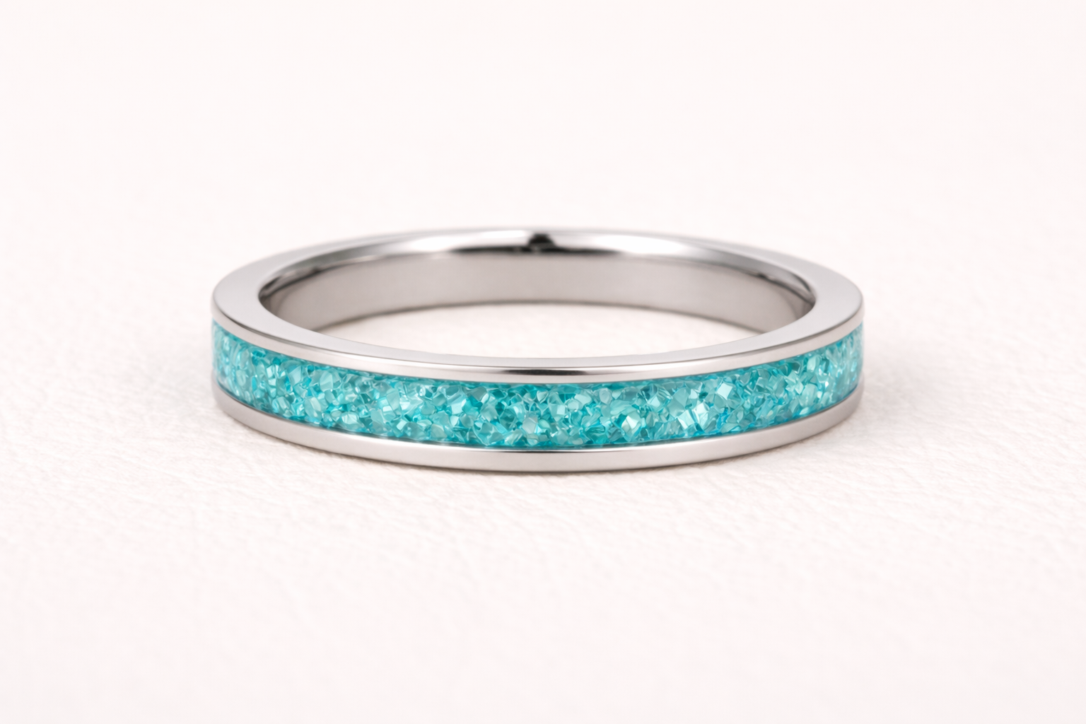 Silver ring with turquoise inlay on a white background