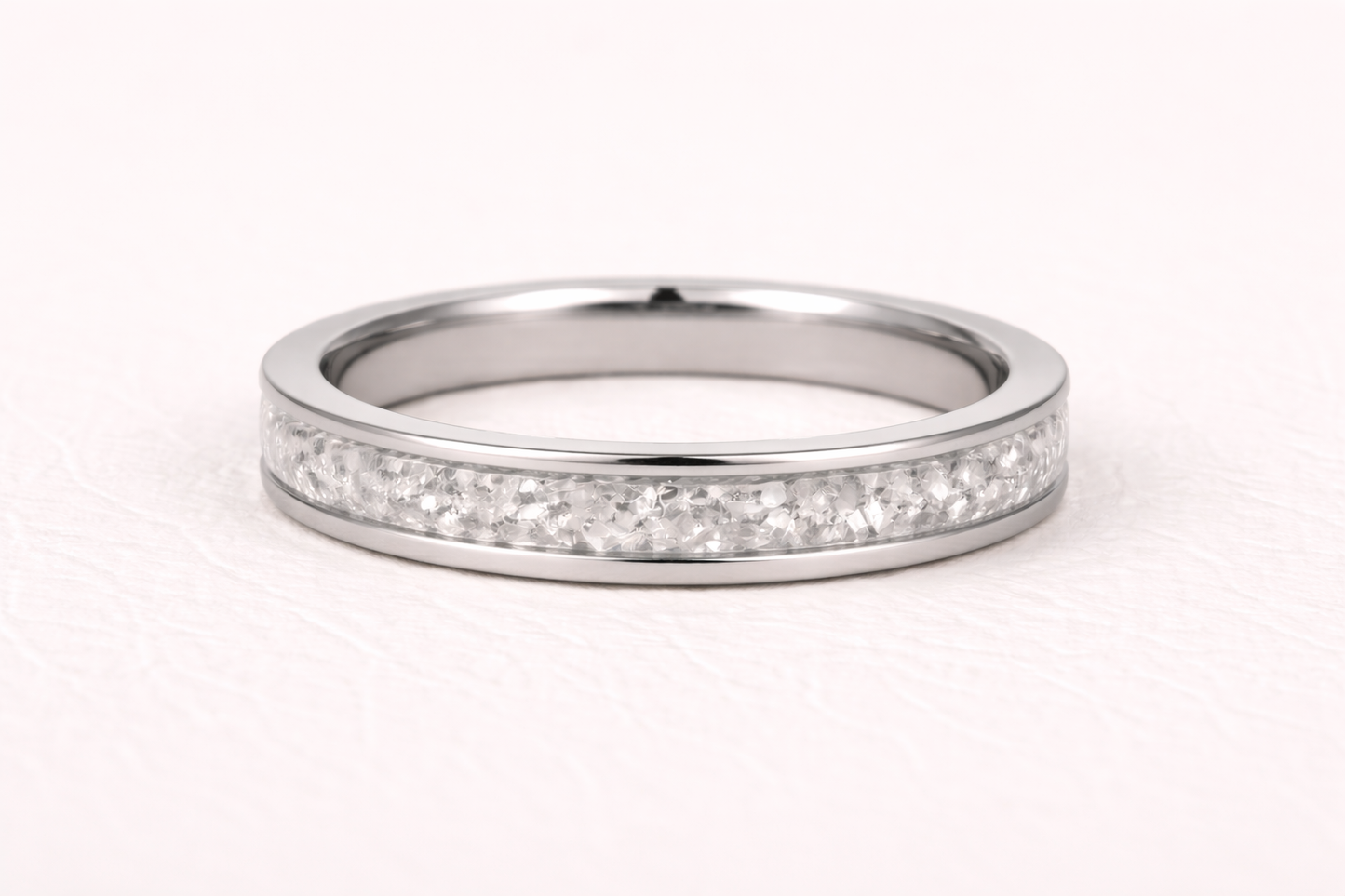 Silver ring with small diamonds on a white background