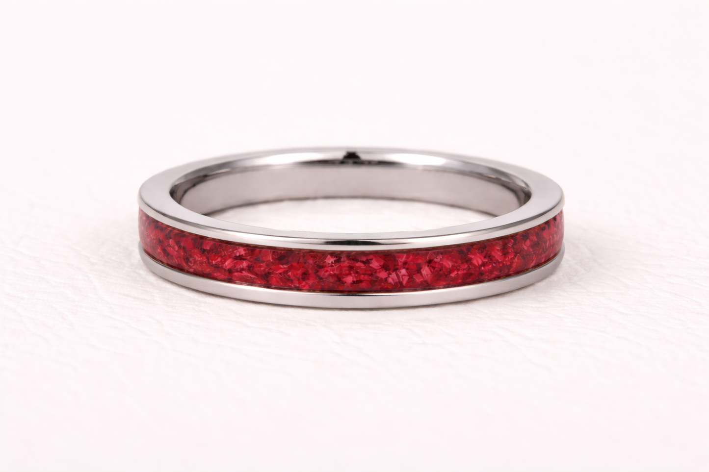 Silver ring with a red inlay on a white background