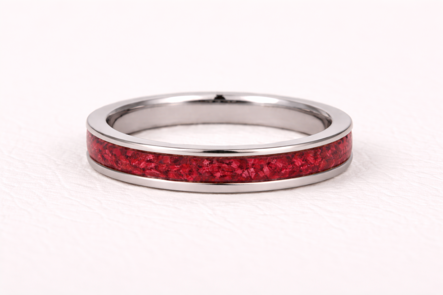 Silver ring with a red inlay on a white background